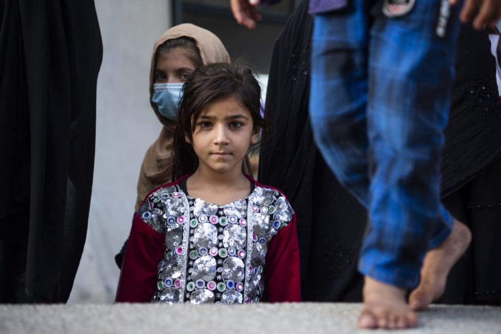 Young Afghan girl it floral top looks directly at camera