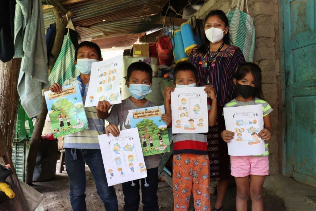 Five young children hold up child-centric posters in Guatemala.