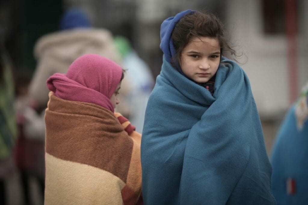 Refugee children fleeing Ukraine are given blankets by Slovakian rescue workers to keep warm at the Velke Slemence border crossing on March 09, 2022.