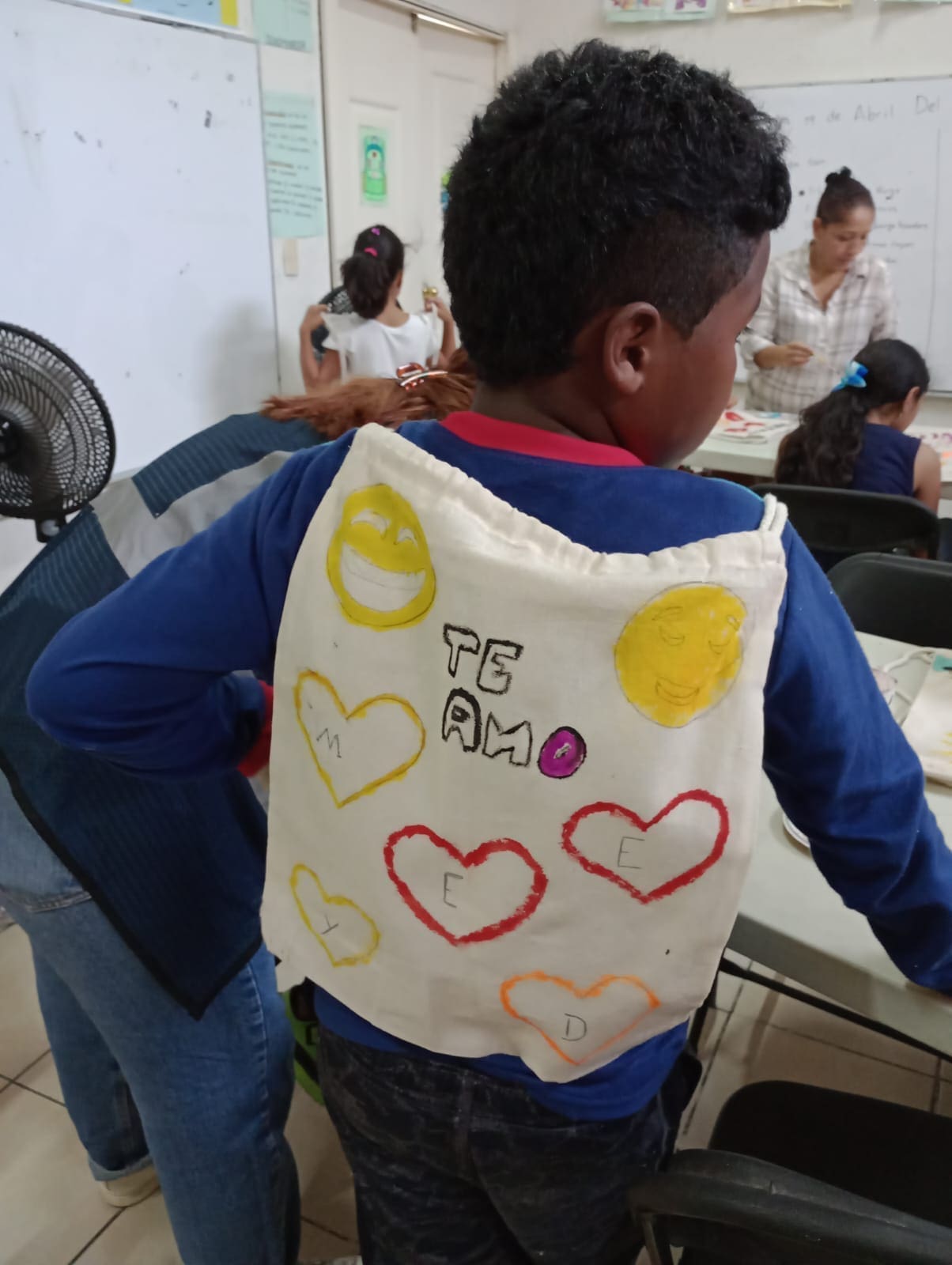 young boy proudly displaying his artwork. 