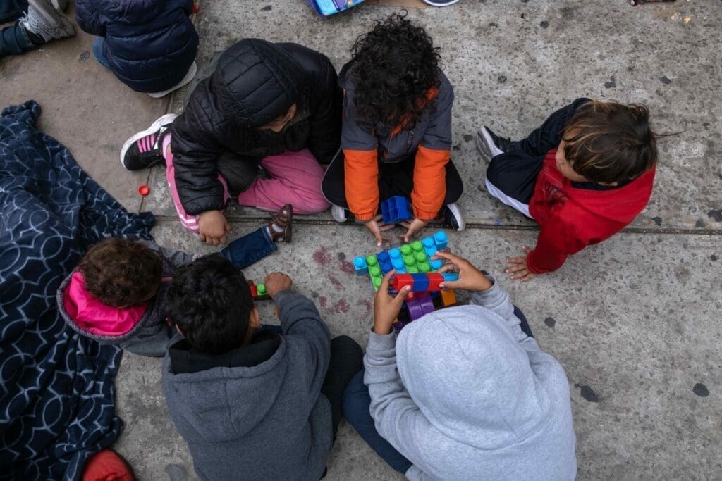 Asylum seeker children play while waiting for US Customs and Border Protection agents to allow them enter the country at the San Ysidro crossing port on the US-Mexico border.