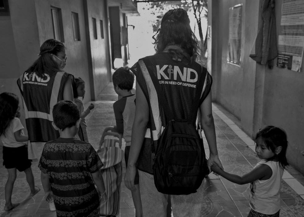 KIND staff walking with children BW