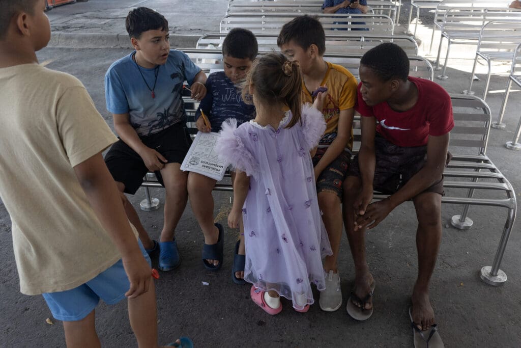 A group of Migrant children from Honduras, Guatemala, and Venezuela study their math homework in a migrant camp.